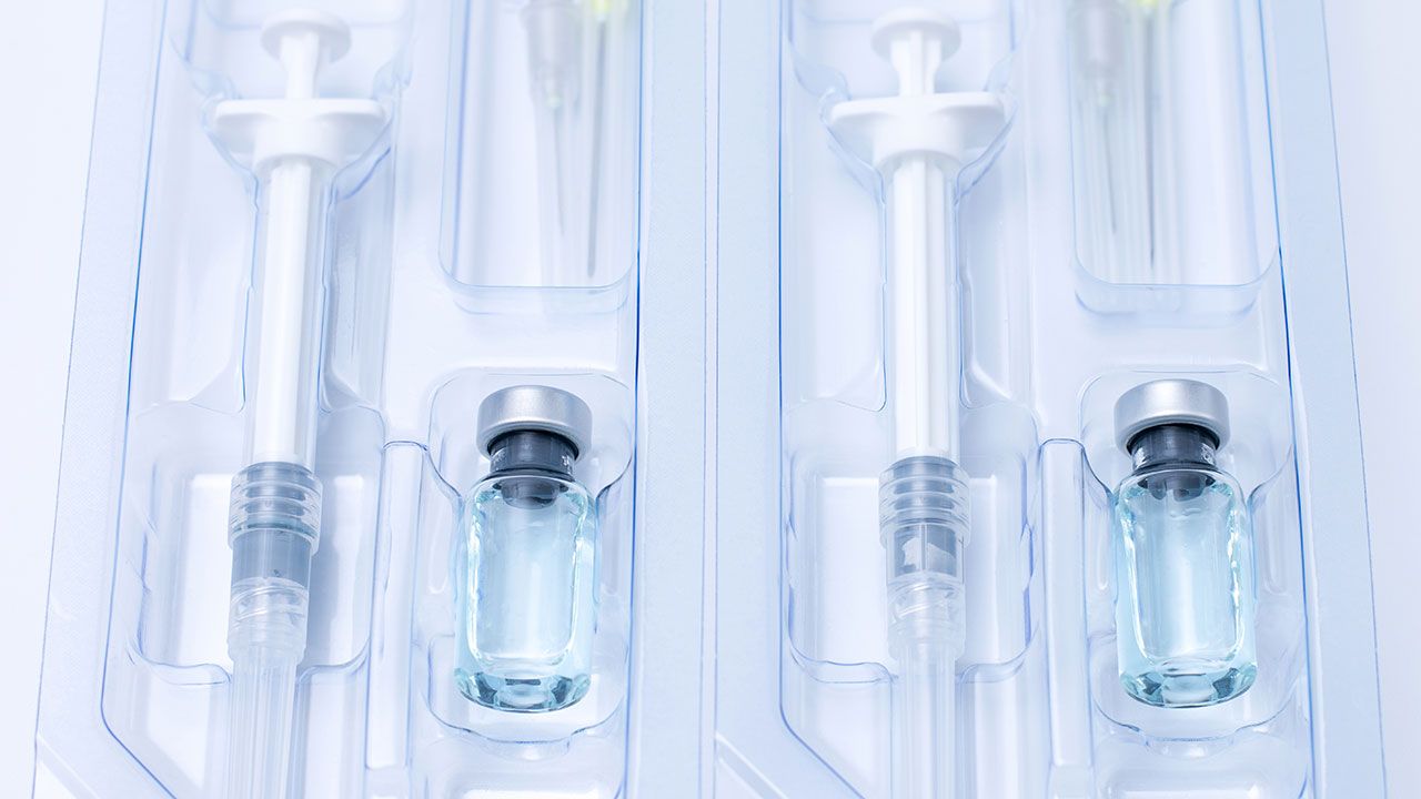 Covid-19, flu, coronavirus liquid vaccine vial bottle and syringe set in plastic package container preparing for injection on white background. Vaccination for fight Covid-19 virus concept. | Image Credit: ©Aonprom Photo -stock.adobe.com