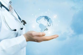 Photograph of a doctor holding a crystal globe representing a world map. | Image Credit: © natali_mis - stock.adobe.com