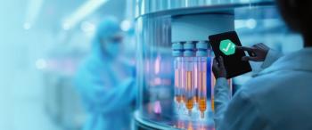 A lab technician in protective gear operates a tablet displaying a green checkmark in a high-tech pharmaceutical laboratory. | Image Credit: © greenbutterfly - stock.adobe.com