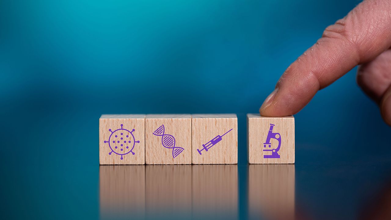 thodonal/Stock.Adobe.com - conceptual image of a hand pushing building blocks, each block containing a symbol representing areas of science research