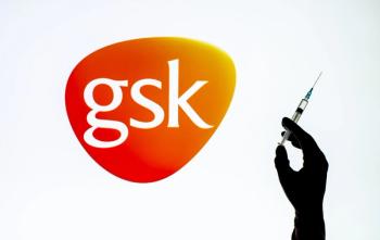 Kyiv, Ukraine - December 22, 2020: Backlit single shot image of GlaxoSmithKline logo on tv screen with a hand holding an Covid-19 vaccine concept | Image Credit: © Олександр Луценко - stock.adobe.com