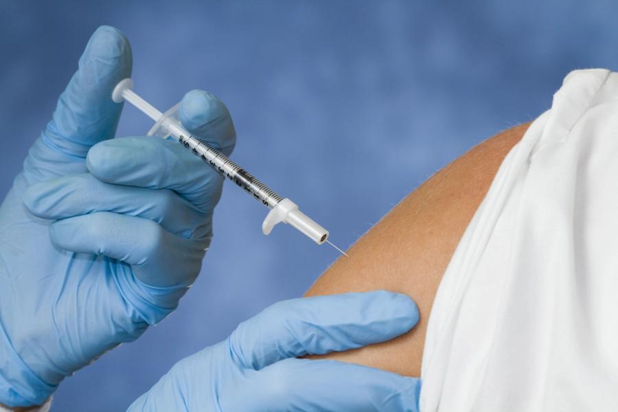 doctor injecting arm with syringe