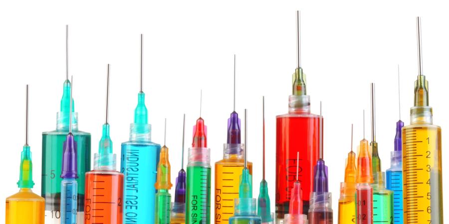 several filled syringes in different sizes and colors