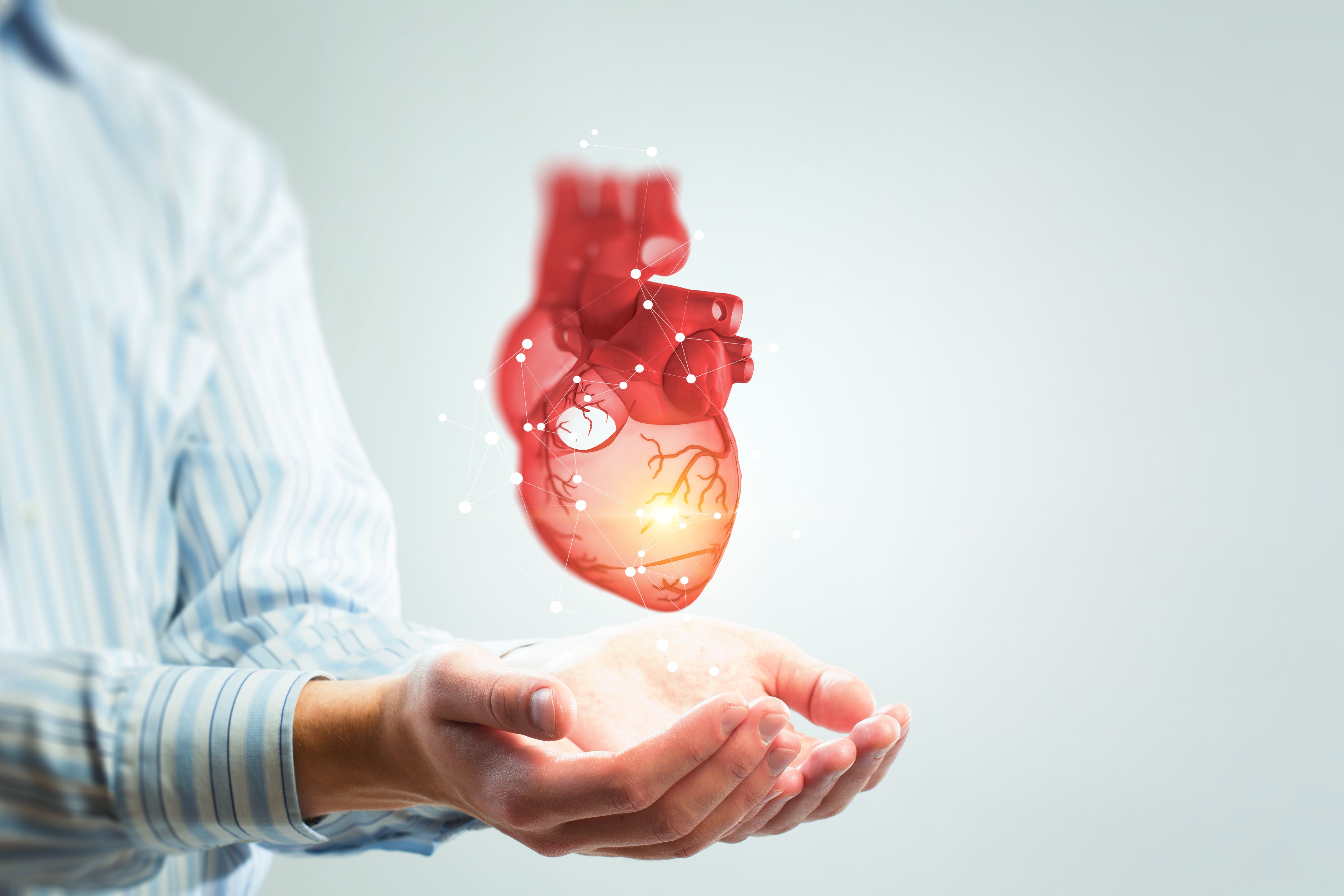 A graphic of a heart hovers over a person's hands. 