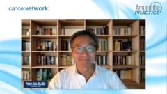 Nelson Chao, MD, smiles for the camera in front of a large wooden bookshelf, wearing glasses and a white button-down shirt.