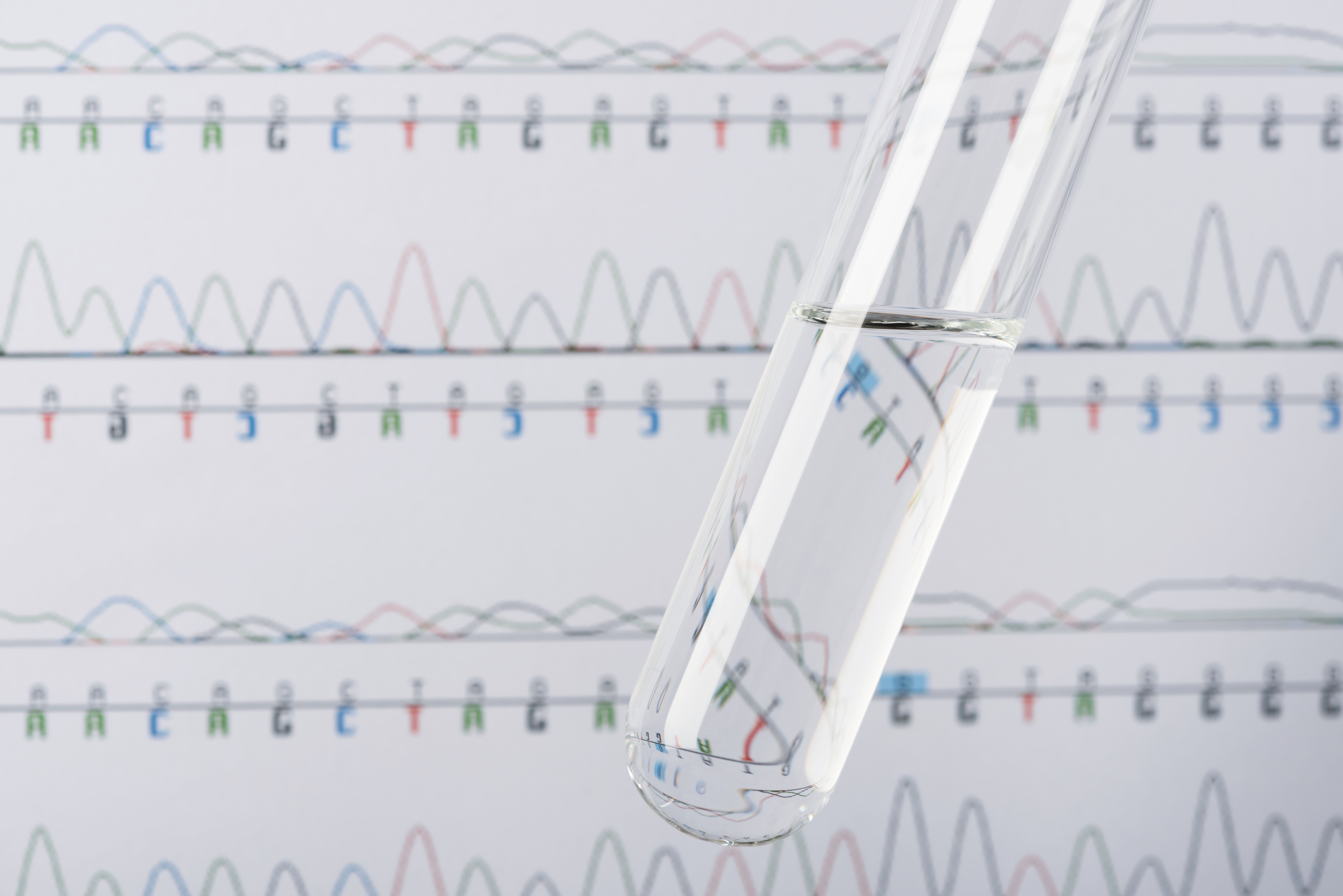 Test tube with transparent liquid and DNA chromatogram on background | Image Credit: © nevodka.com - stock.adobe.com