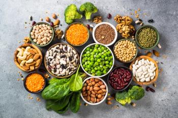 Vegan protein source. Legumes, beans, lentils, nuts, broccoli, spinach and seeds. Top view on stone table. Healthy vegetarian food. | Image Credit: © nadianb - stock.adobe.com