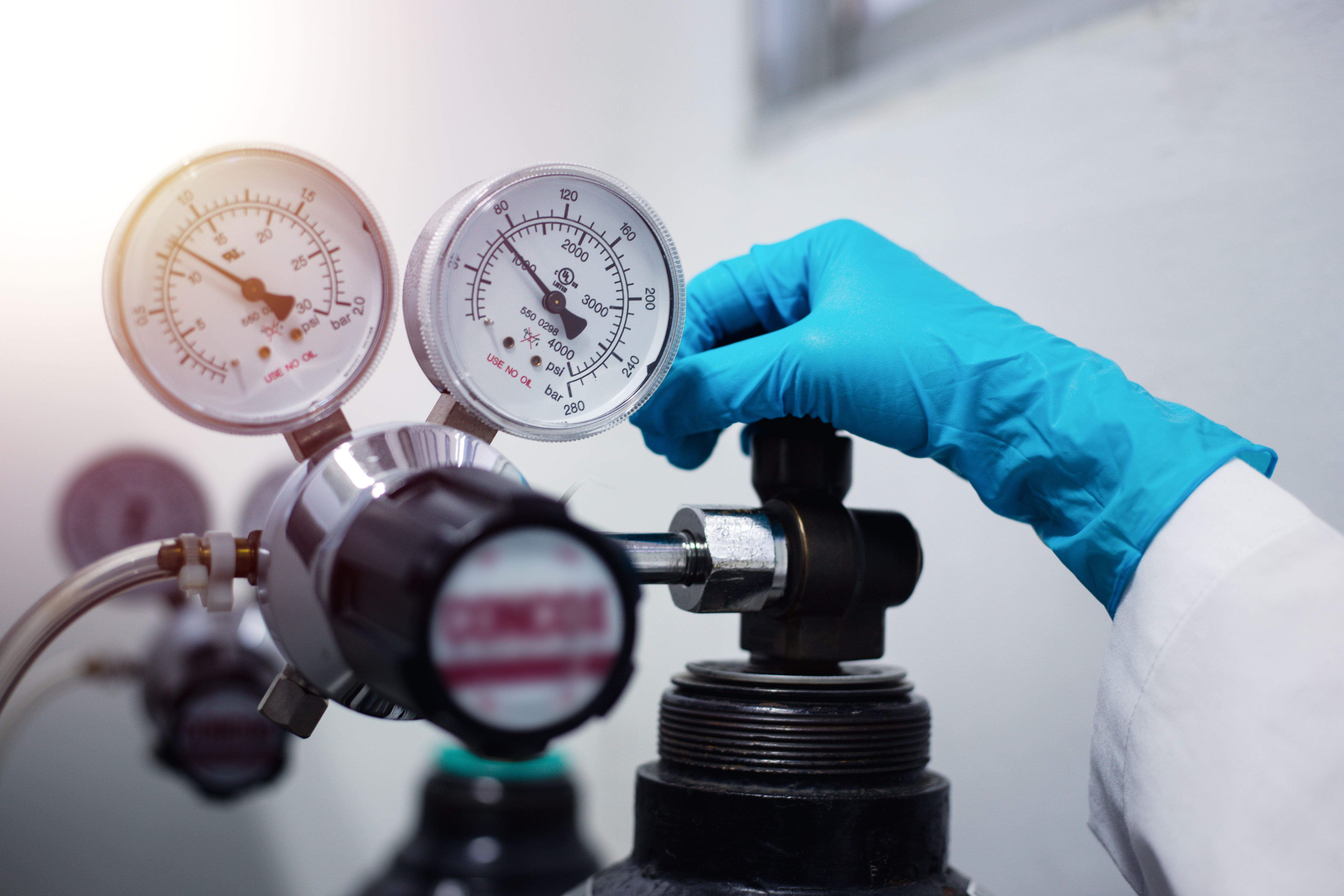 Closeup of a scientist's hand, checking gas from pressure gauge for a laboratory chromatography device during research | Image Credit: © S. Singha - stock.adobe.com