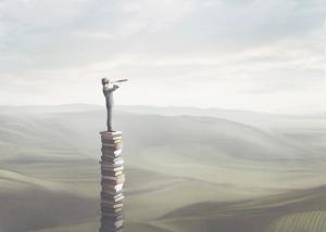 man standing on books looking out at the view – visual representation of overcoming ignorance