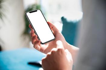 Man using smartphone blank screen frameless modern design while lying on the sofa in home interior | Image Credit: © guteksk7 - stock.adobe.com