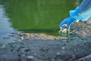 Close-up environmentalist hand of a researcher in a process of taking a sample of contaminated water from a lake | Image Credit: © Daniel CHETRONI - stock.adobe.com