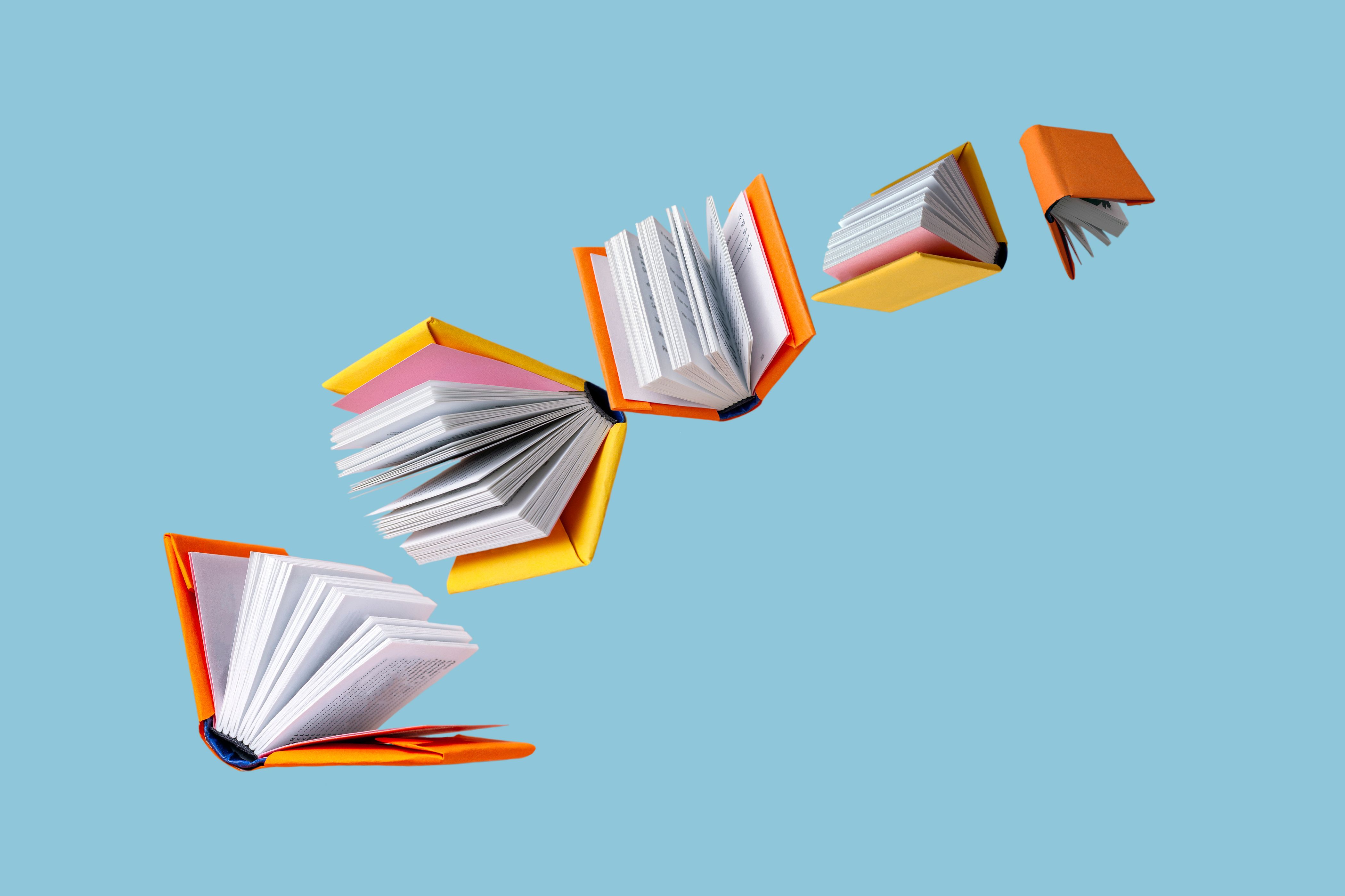 Books in colored covers swirl on a blue background, copy space | Image Credit: © Rara - stock.adobe.com