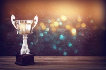 low key image of trophy over wooden table and dark background | Image Credit: © tomertu - stock.adobe.com