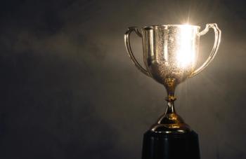 champion golden trophy placed on wooden table | Image Credit: © fotobieshutterb - stock.adobe.com.
