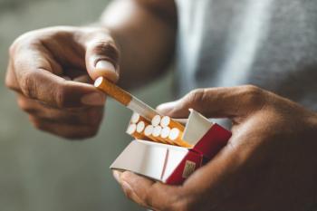 Close up male hand holding a cigarette. | Image Credit: © Nopphon - stock.adobe.com