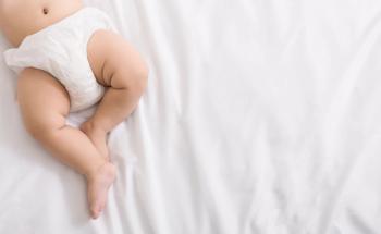 Baby legs and bottom in diaper on bed | Image Credit: © Prostock-studio - stock.adobe.com