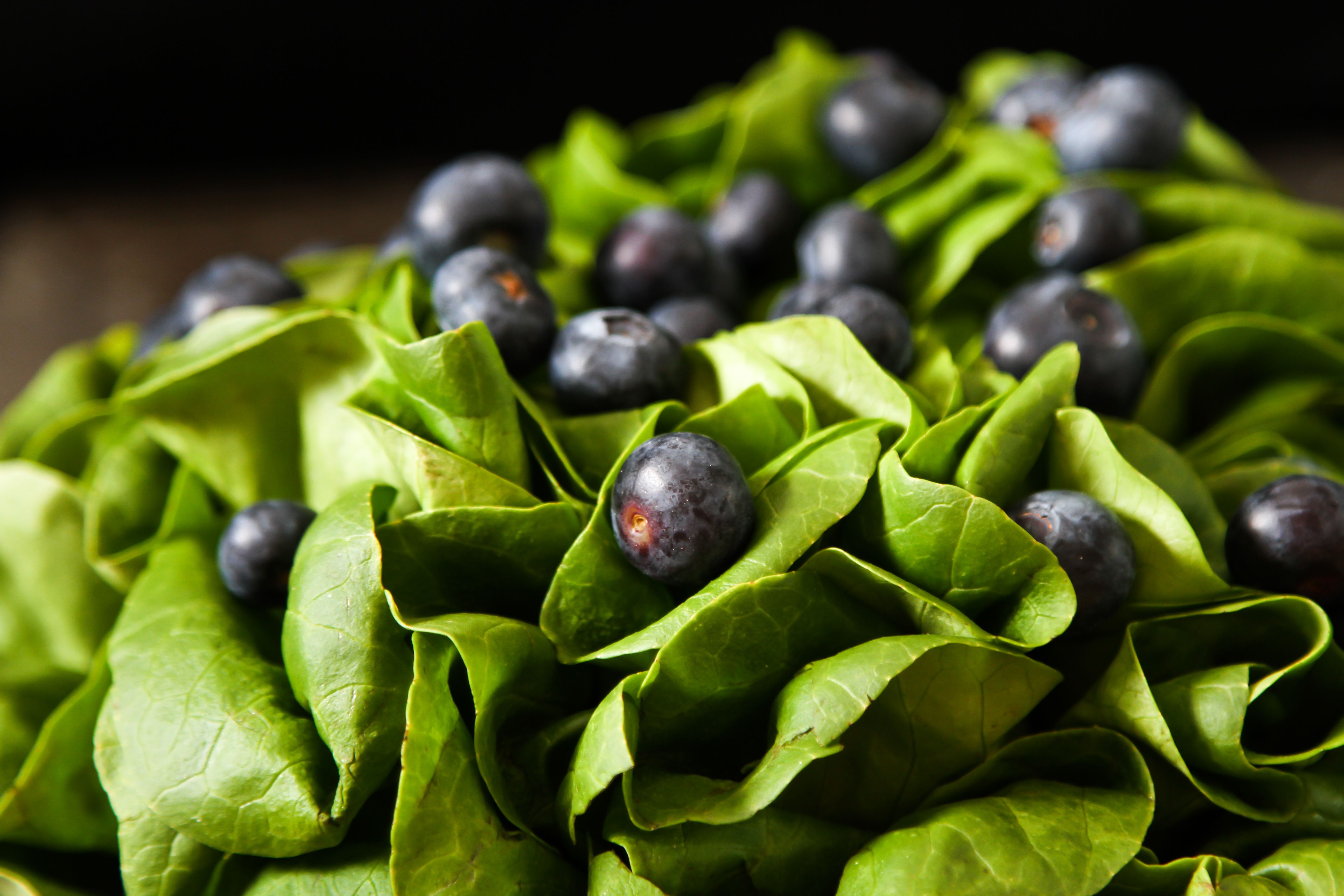 Fresh lettuce with blueberry, lemon and strawberries on a wooden | Image Credit: © naltik - stock.adobe.com