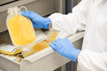 Doctor hand wearing blue gloves holding fresh frozen plasma bag in storage blood refrigerator at blood bank unit laboratory.Human plasma for covid-19 patients treatment | Image Credit: © arcyto - stock.adobe.com