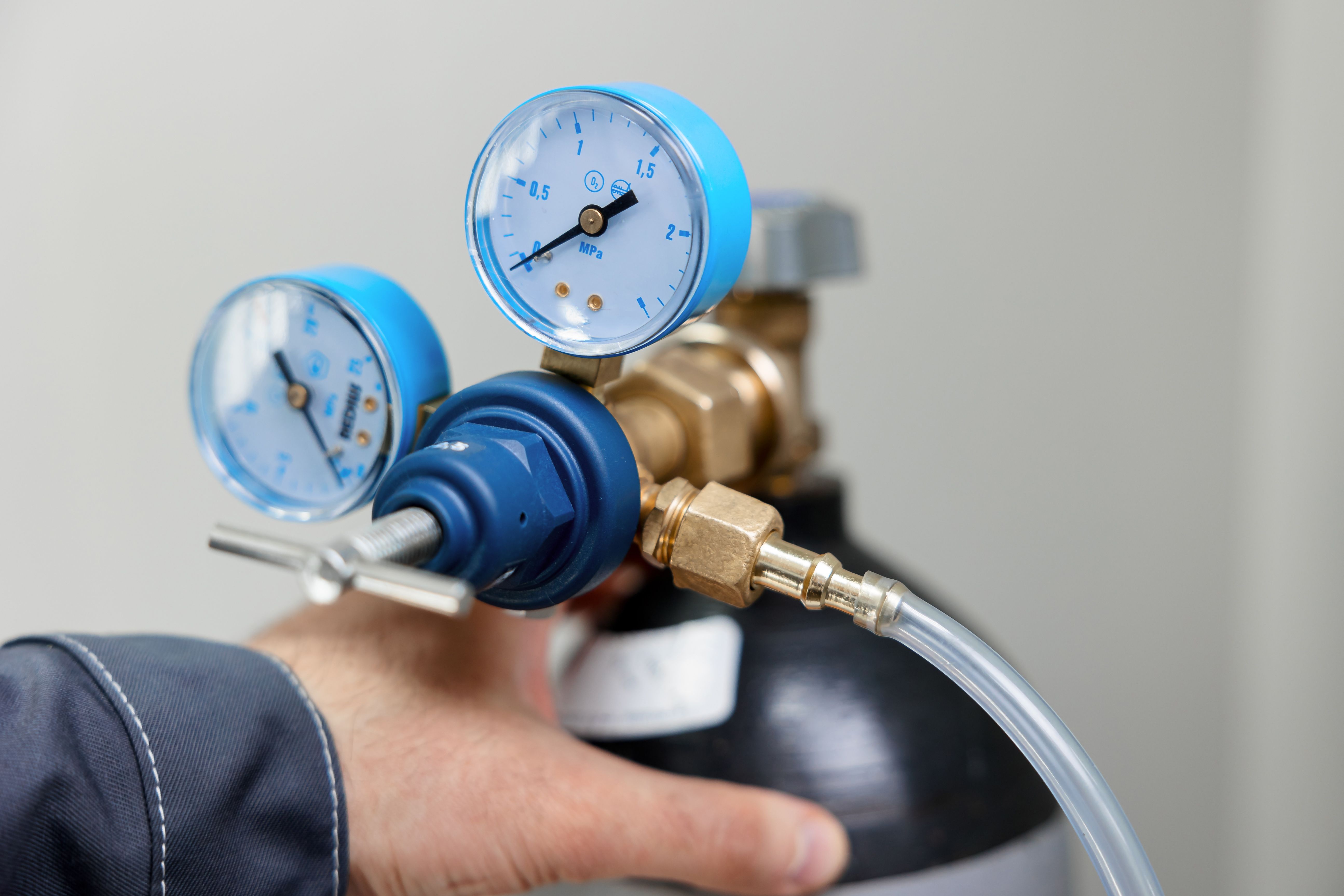 A metrology laboratory specialist takes a compressed gas cylinder for testing and calibration with a chromatograph. A man connects a hose for gas analysis. Gas analyzer and chromatography. | Image Credit: © NEZNAEV