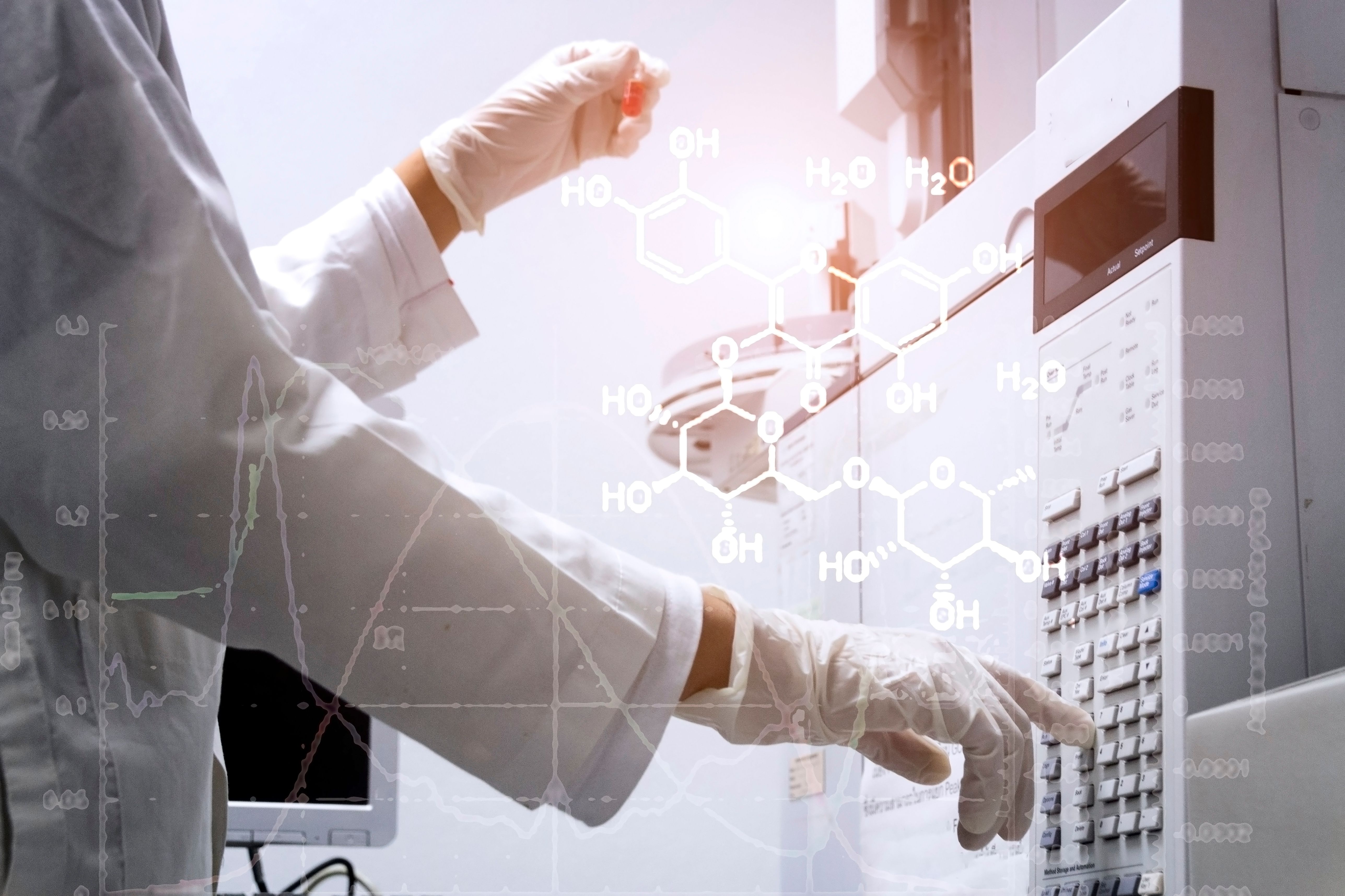 scientist holds an amber vial and press the control button of GC chromatography | Image Credit: © Anchalee - stock.adobe.com
