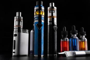 Electronic cigarettes and bottles with vape liquid on black background | Image Credit: © makcoud - stock.adobe.com