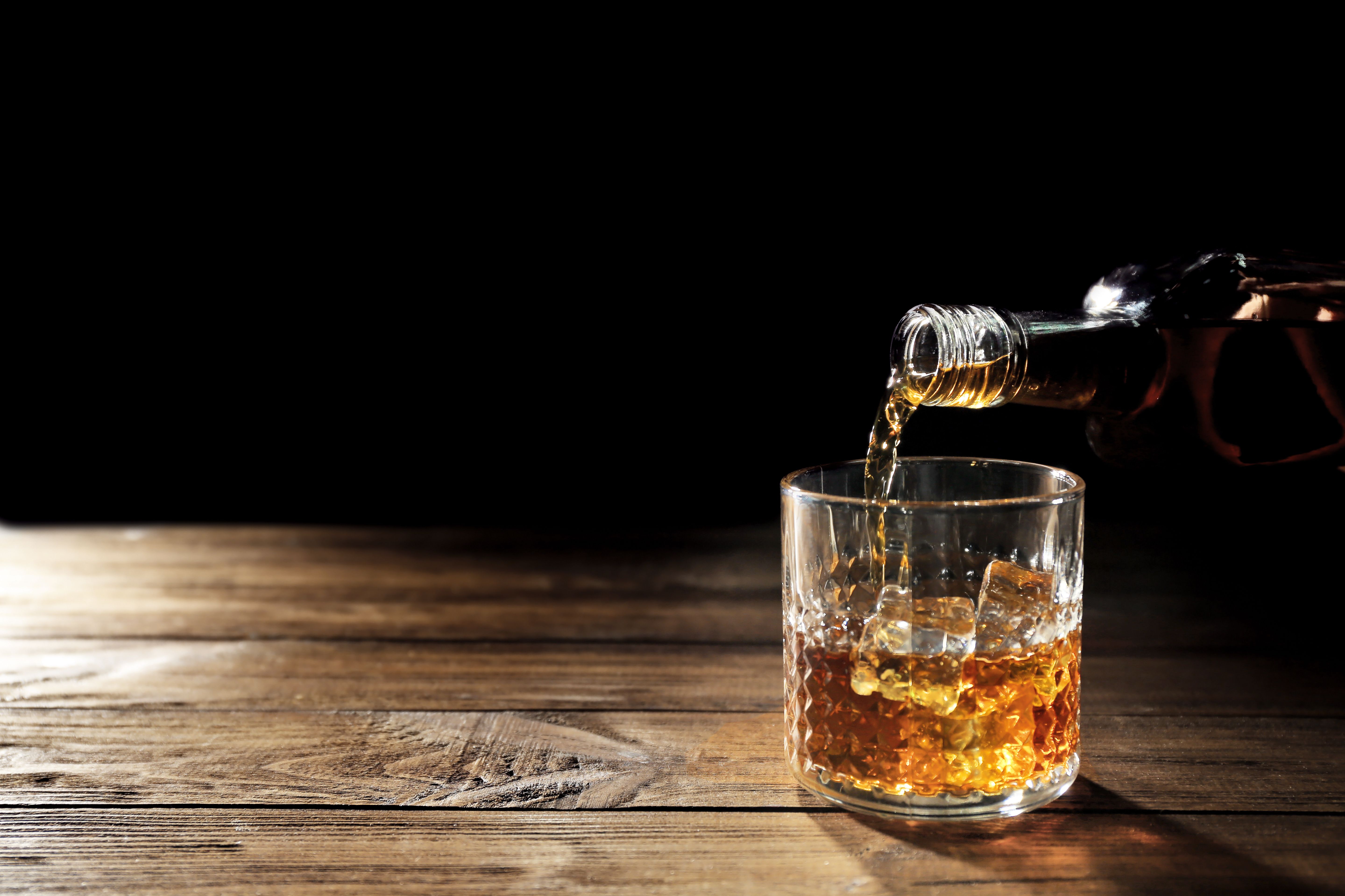 Pouring whisky into glass on wooden table closeup | Image Credit: © Africa Studio - stock.adobe.com