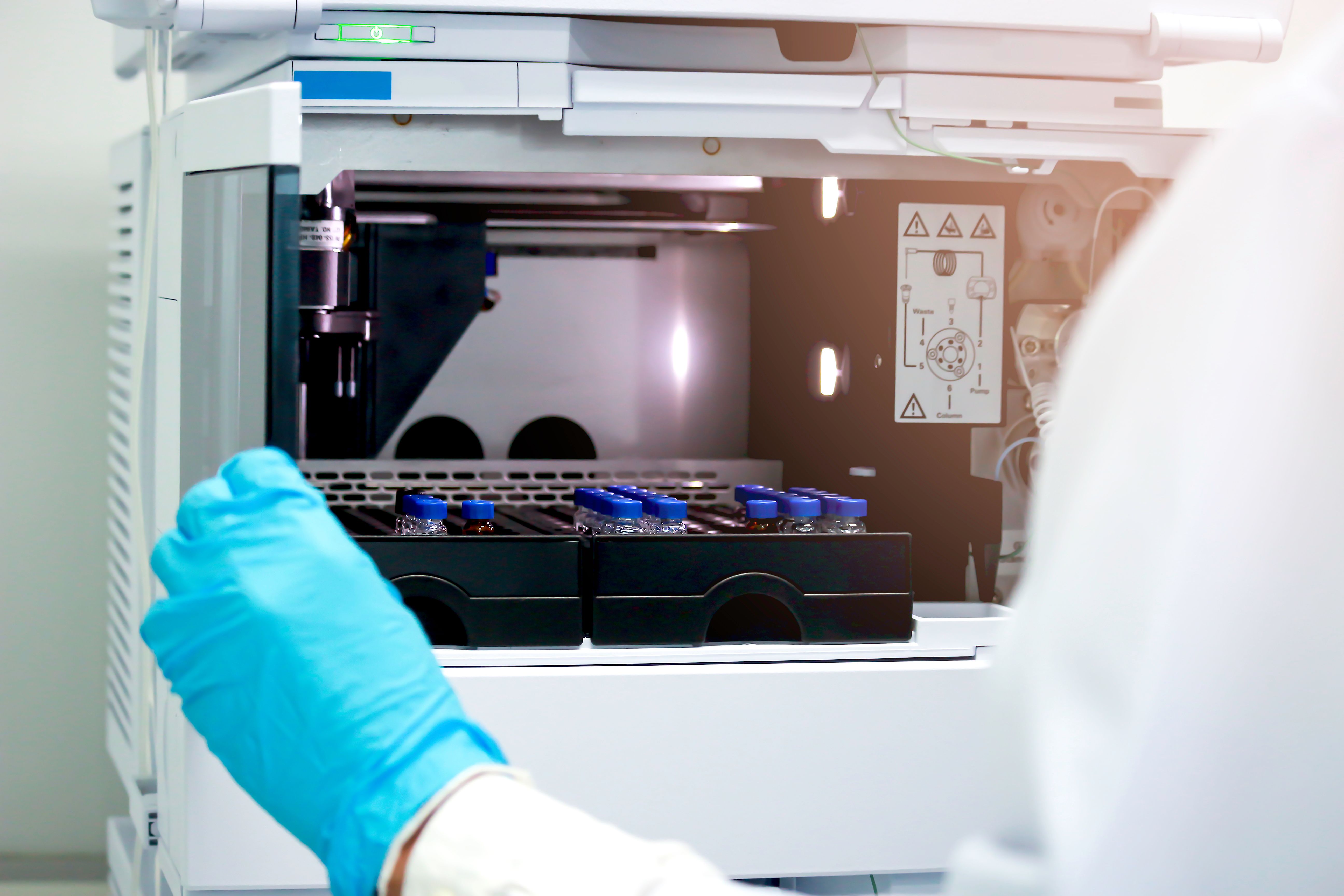 Vials (small bottle) in tray inside injection section of High Performance Liquid Chromatography (HPLC) instrument, chemistry analytical experiment concept | Image Credit: © Stella - stock.adobe.com