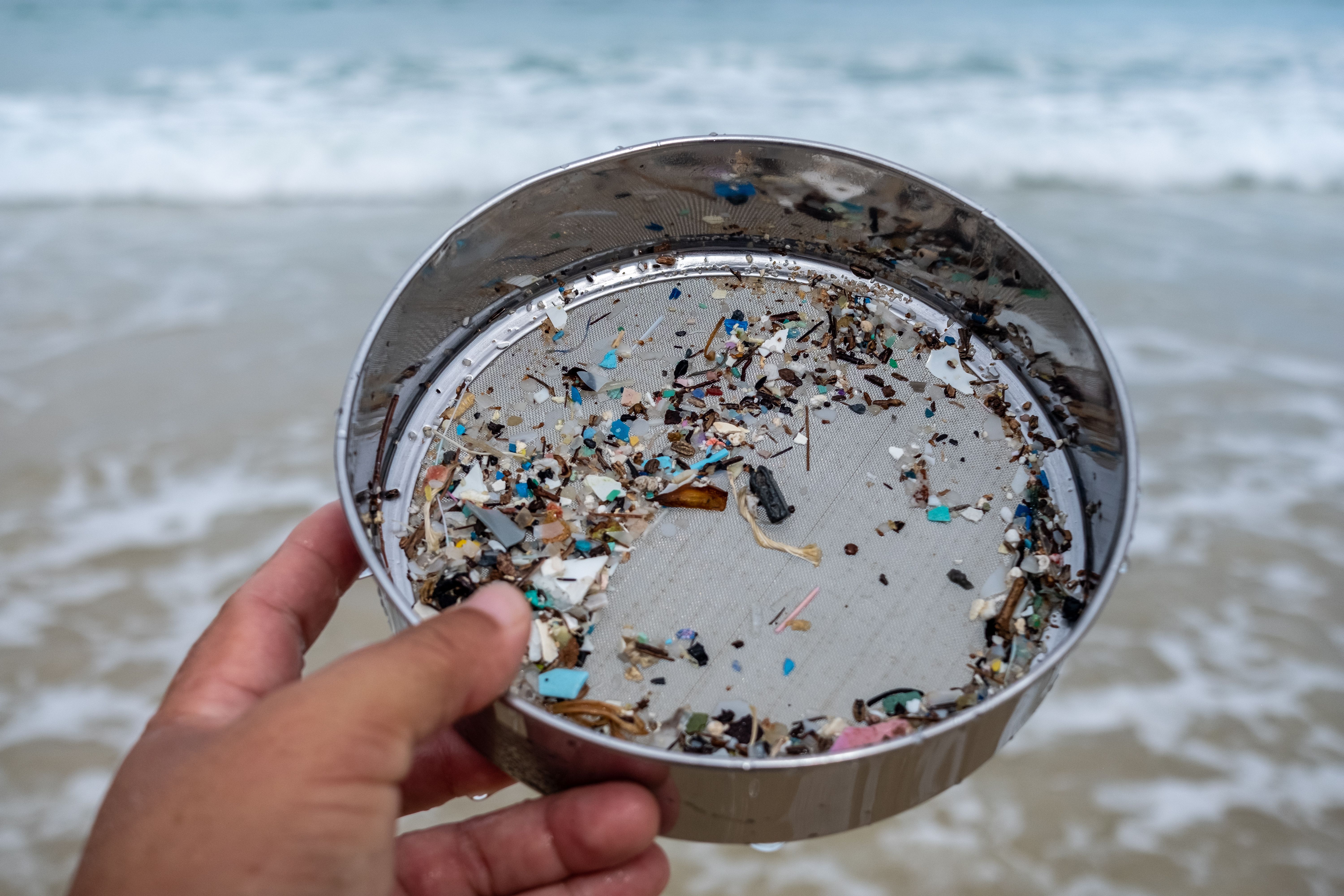 Environmentalists filter the microplastic waste contaminated with the seaside sand. | Image Credit: © wonderisland - stock.adobe.com