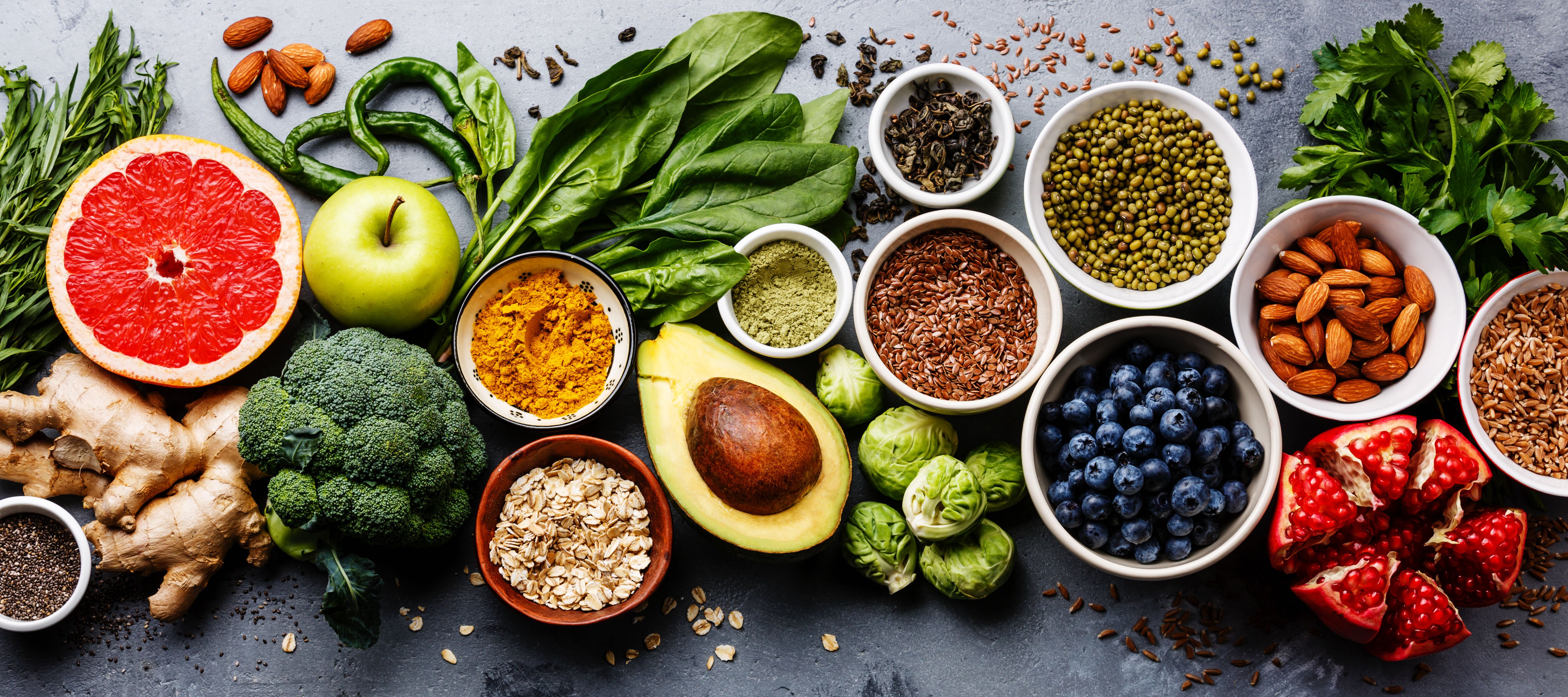 Healthy food clean eating selection: fruit, vegetable, seeds, superfood, cereal, leaf vegetable on gray concrete background | Image Credit: © Natalia Lisovskaya - stock.adobe.com