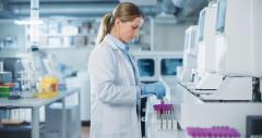 Portrait of a Female Lab Scientist at Work in a Modern Medical Research Facility. Bioengineer in a White Coat Handling Test Tubes and Putting Them Inside an Advanced Machine for Analysis | Image Credit: © Gorodenkoff - stock.adobe.com.