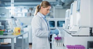 Portrait of a Female Lab Scientist at Work in a Modern Medical Research Facility. Bioengineer in a White Coat Handling Test Tubes and Putting Them Inside an Advanced Machine for Analysis | Image Credit: © Gorodenkoff - stock.adobe.com.