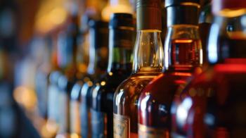 Assorted liquor bottles in a bar with focus on the foreground. Generated with AI. | Image Credit: Artyom - stock.adobe.com