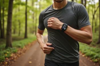 Runner on forest trail wearing smartwatch for fitness tracking and outdoor exercise. | Image Credit: © S u n n y B u n n y - stock.adobe.com