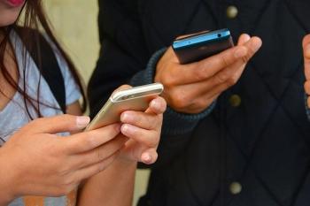 two people texting on mobile phones