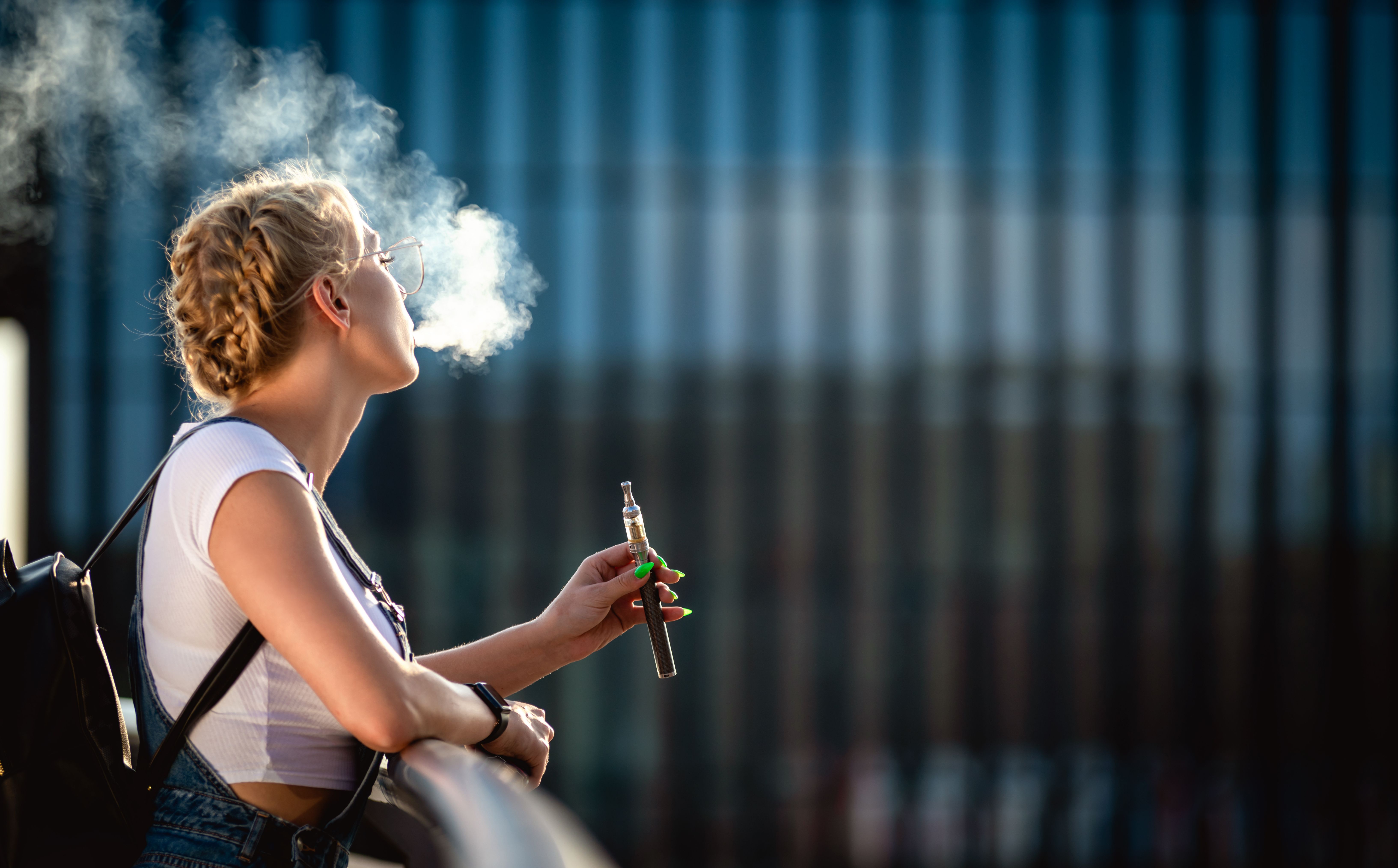 В тайланде можно курить сигареты. Девушка выдыхает дым. Youth smoking. Курение в спецодежде.