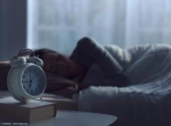 Woman sleeping in her bed and alarm clock | Image Credit: © stokkete - stock.adobe.com
