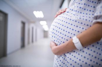 Mid section of pregnant woman standing in corridor | Image Credit: © WavebreakMediaMicro - stock.adobe.com