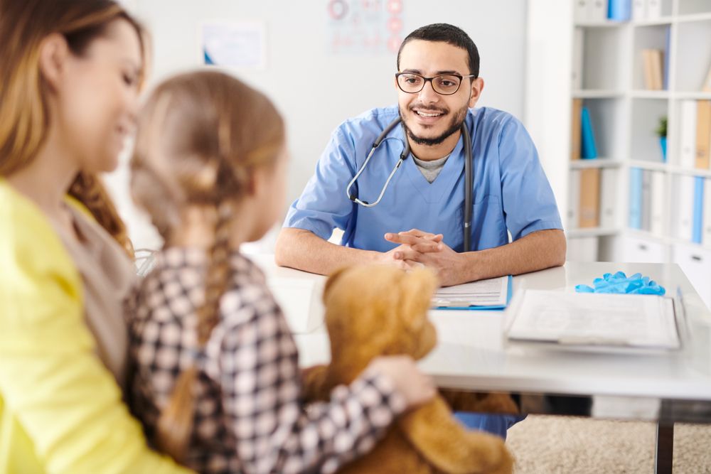 stock image of pediatrician speaking to patient and parent