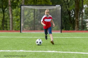 child playing soccer in a mask