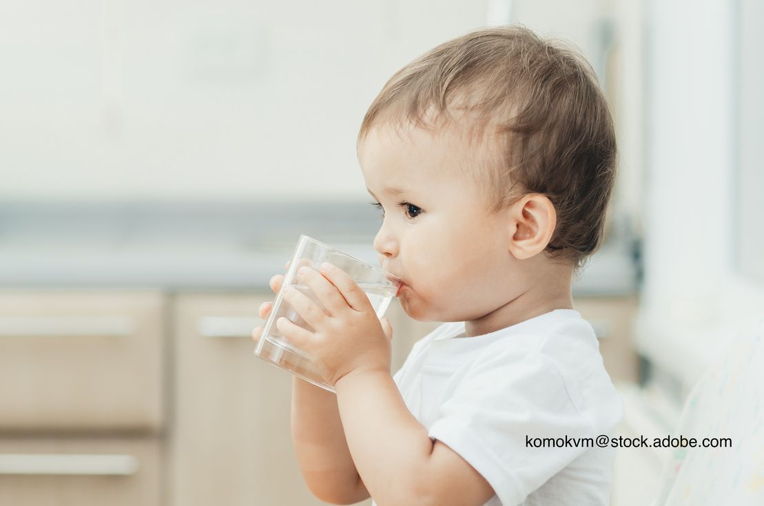 child drinking a glass of water