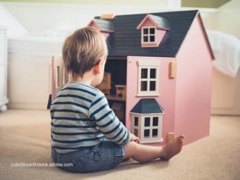 boy playing with a dollhouse