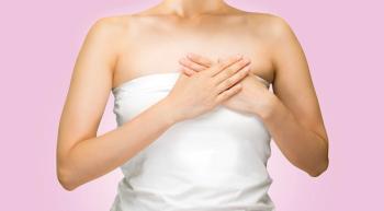 woman on pink background, holding breast
