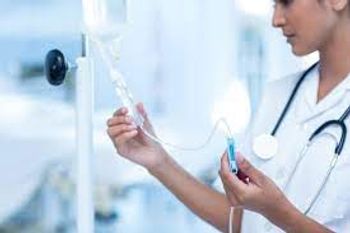Image of a doctor holding treatment on an IV pole.