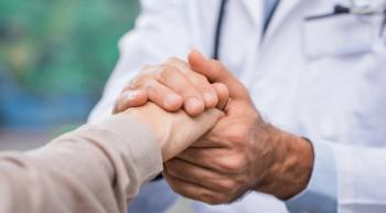 Image of a patient holding a doctor's hand. 