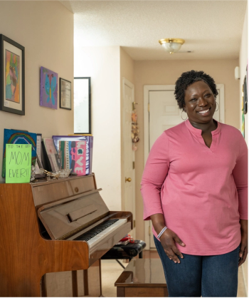 Cancer survivor, Marlena Murphy, a middle-aged black woman with short hair, smiles at the camera