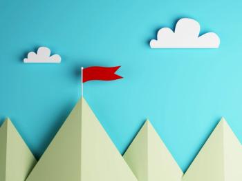 paper mountains with a red flag on top of one