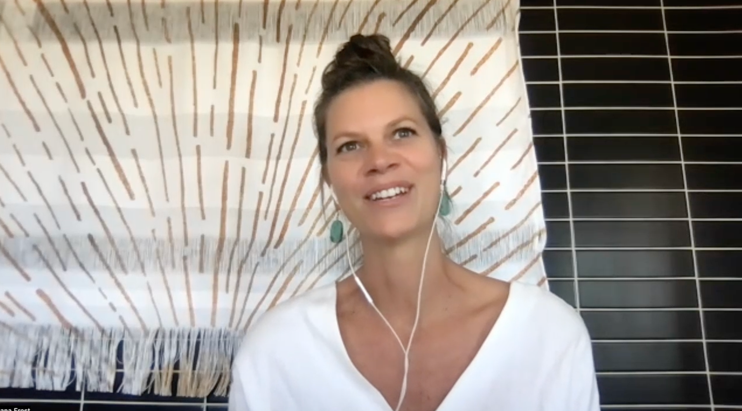Image of a woman with a brown hair tied into a bun. 