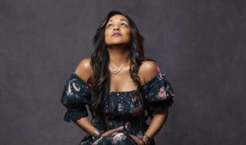 Image of a woman with dark curly hair looking up.