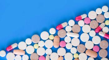 many multi-colored pills against a blue background