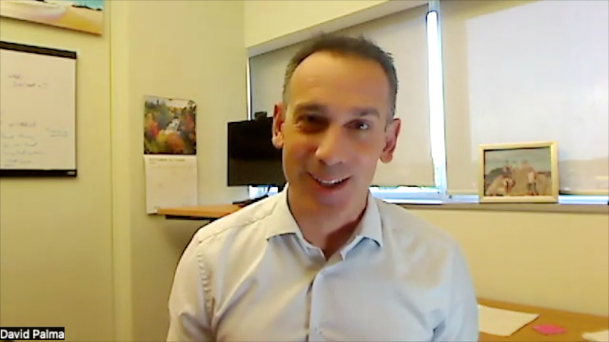 Image of a man with short hair, wearing a buttoned-up shirt.